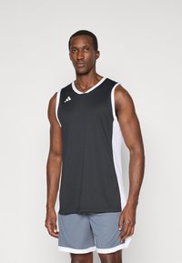 Zwarte mouwloze sportshirt met witte zijpanelen en een V-hals. Bevat een klein driekleurig logo op de bovenste linkerkant van de borst.