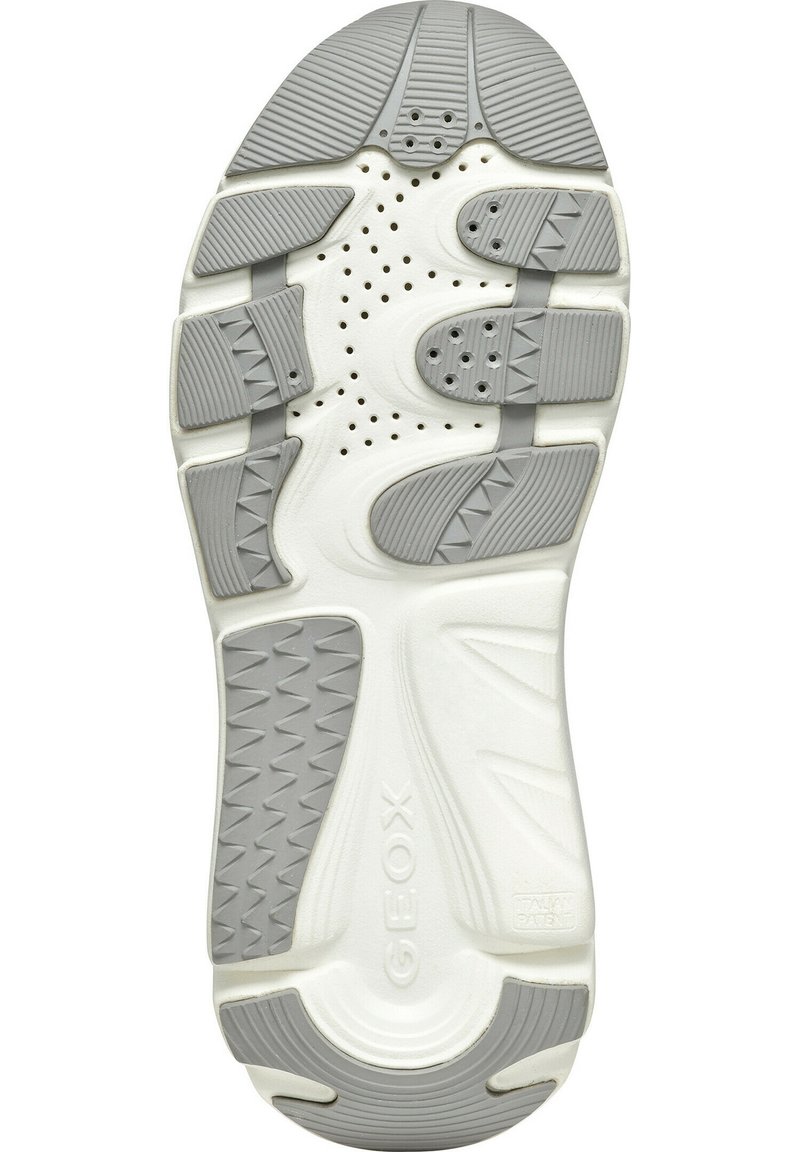 Semelle de chaussure en caoutchouc blanc présentant un motif de bande de roulement texturé gris, des trous de ventilation et des éléments de design géométrique pour l'adhérence et le soutien.