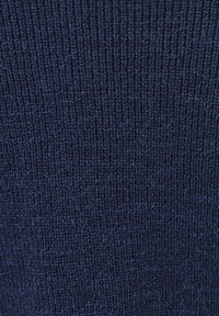 Ciemnogranatowy dziany materiał z teksturowanym wzorem prążkowym. Zawiera jaśniejsze niebieskie nitki, dodające subtelnej głębi wizualnej. Miękki i lekko puszysty wygląd.