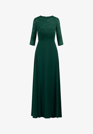 Lang grøn kjole med spidse ærmer, trekvart ærmer, rund halsudskæring og en flydende nederdel lavet af blødt stof.