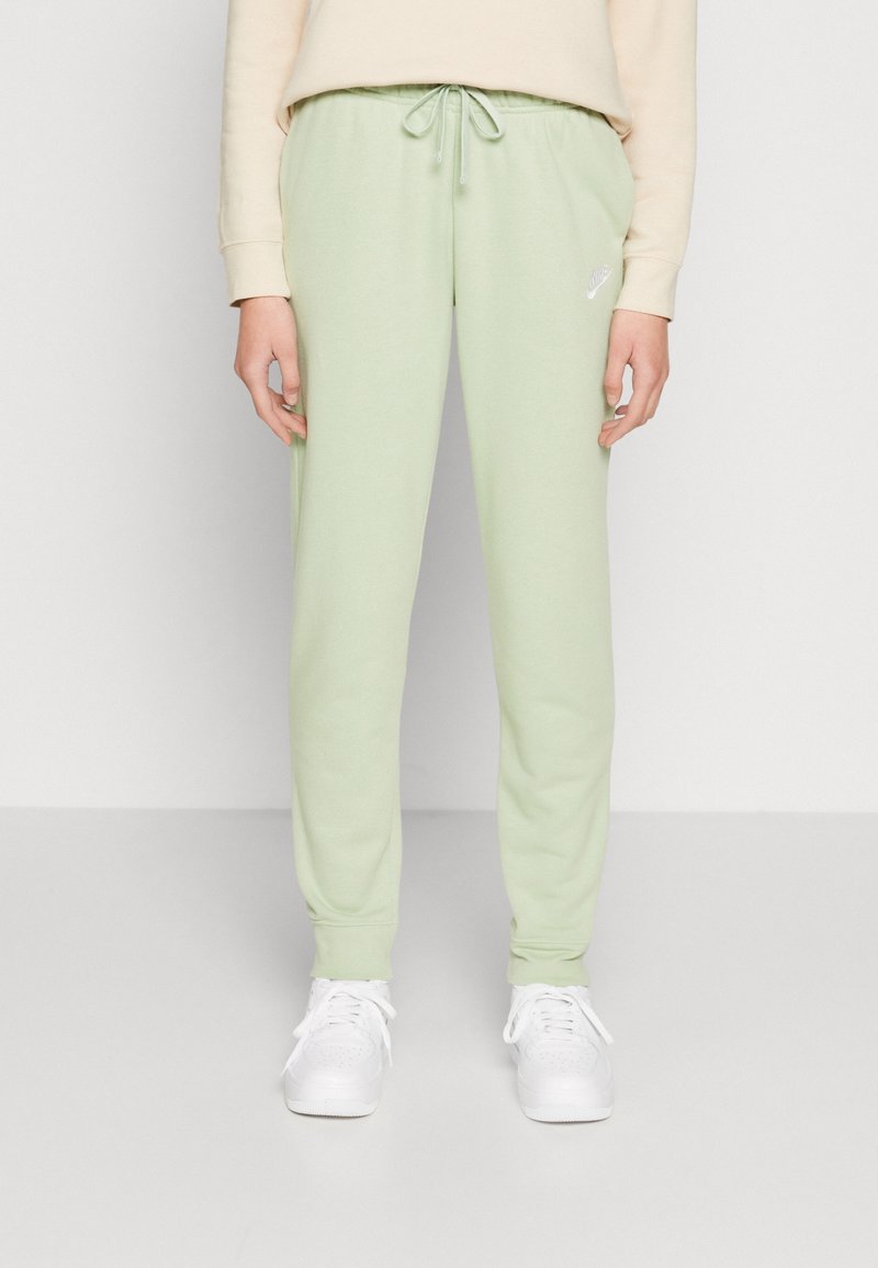 Pantalones de chándal verde claro con cintura ajustable, hechos de material suave, con un pequeño logo blanco de Nike en el lado izquierdo.
