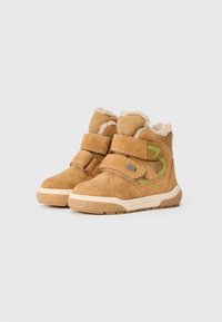 Tanfarbene Wildleder-Ankle-Boots mit gepolstertem Kragen, fleecegefüttert und zwei verstellbaren Klettverschluss-Riemen. Ausgestattet mit einer Gummisohle und grünen Akzenten.