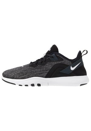 Zwarte en grijze Nike sportschoen met witte zool, veters aan de voorkant, gevoerde kraag en Nike-logo op de hielband en zijkant.
