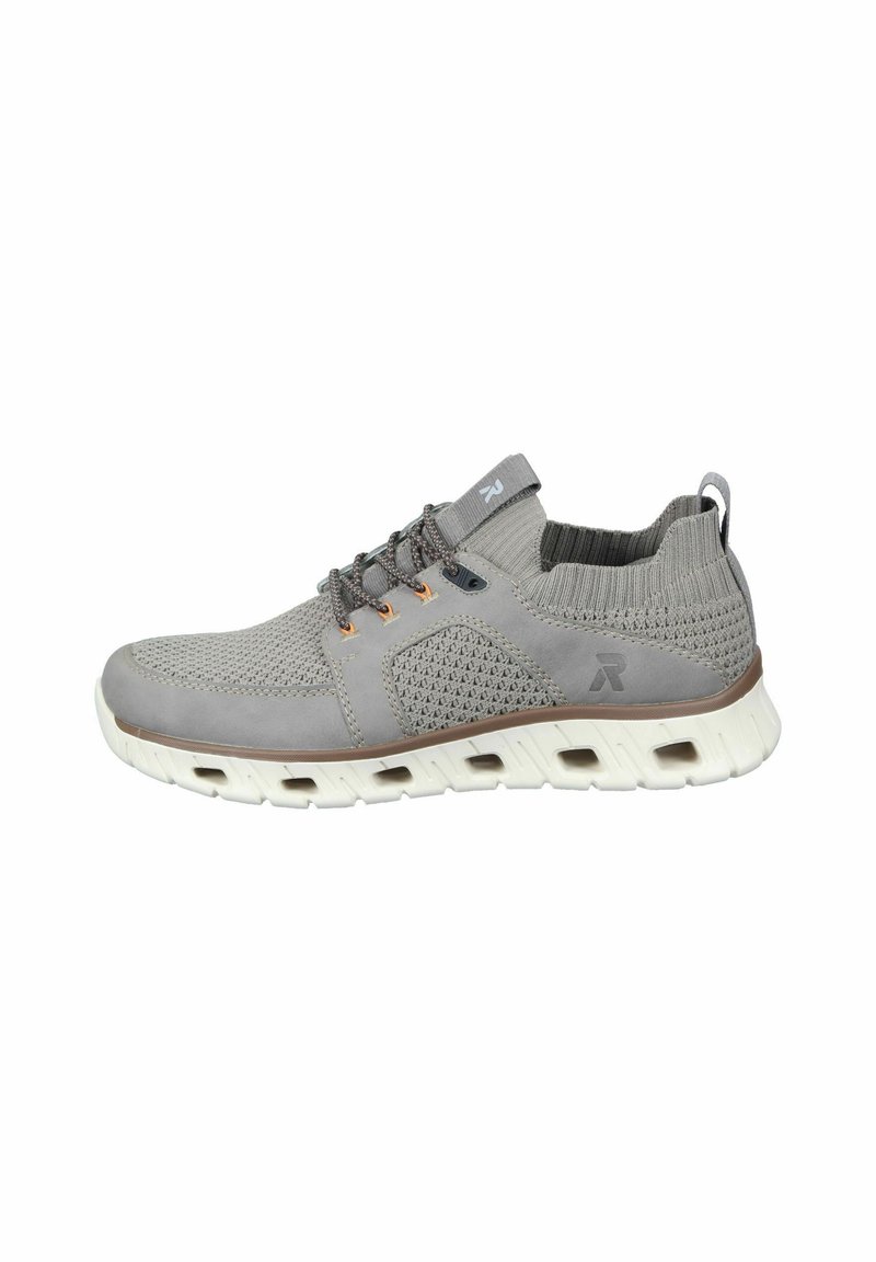 Zapatillas deportivas de color gris claro con parte superior de malla texturizada, secciones elásticas y suela blanca en contraste. Presenta cordones grises y un logo en el lateral.