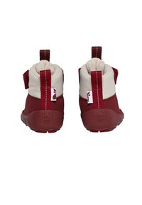Chaussures pour enfants rouges et beiges avec un dessus rembourré et doux et une semelle en caoutchouc texturée ; elles sont dotées de tirants et d'un logo sur le talon.