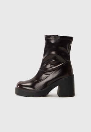 Shiny black ankle boot with chunky block heel and round toe, smooth leather upper with subtle stitching details.
