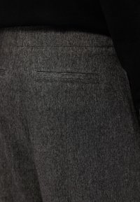 Šedé kalhoty s přesným střihem vyrobené z texturované látky, s límcovou kapsou na zadní straně, hladkým pásem a vybraným provedením.