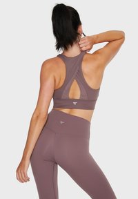 Sportbeha en legging set in een mauve kleur, met een kruisrugontwerp en een strakke textuur, met een logo op de tailleband.