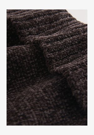 Getextureerde donkerbruine stof met een geribd patroon, met zachte vezels en een weelderig uiterlijk, in lagen gevouwen.