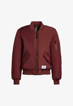 Burgunderfarbene Bomberjacke mit Reißverschluss vorne, gerippten Bündchen und Saum, zwei Fronttaschen und einer Reißverschlusstasche am linken Ärmel. Glattes, glänzendes Material.