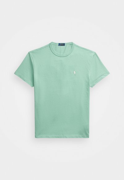 Mėtų žalios spalvos marškinėliai, pagaminti iš minkštos medvilnės. Turi apvalų kaklą ir trumpas rankoves, o kairėje krūtinės pusėje yra mažas siuvinėtų logotipas.