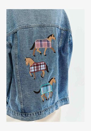 Kurtka jeansowa z trzema wyszywanymi końmi, noszącymi kratkowane koce w kolorach różowym, czerwonym i niebieskim na plecach.