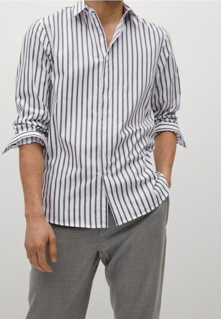 Miesten valkoinen pitkähihainen paita, jossa pystysuorat tummansiniset raidat, napillinen kaulus, rento istuvuus ja käärityt hihat. Yhdistetty vaaleanharmaiden housujen kanssa.