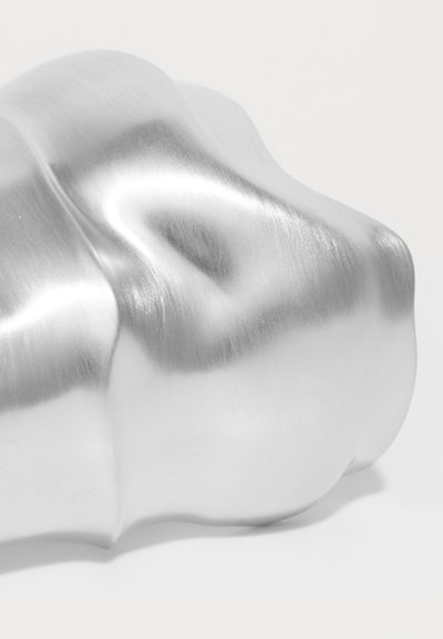 Aluminijski predmet s glatkom, refleksivnom površinom; sadrži zakrivene, organské oblike i suptilnu četкану teksturu.