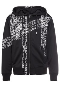 Sweat à capuche zippé noir avec texte blanc "JUST CAVALLI" répété en diagonale sur la poitrine, les manches et le devant, doté d'une capuche avec cordon de serrage et de poignets côtelés.
