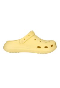 Gelber Gummiclue mit Lüftungslöchern und verstellbarem Fersenriemen, seitlich dargestellt vor weißem Hintergrund.