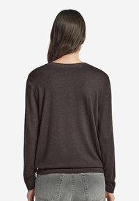 Mörkbrun tröja med långa ärmar, rund halsringning och ribbad nederkant. Mjukt material; minimalistisk design utan synliga mönster eller detaljer.