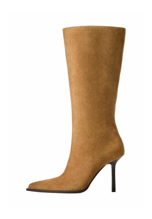 Knie hoge suède laarzen in kamelkleur met een spitse teen en een dunne hoge hak. Glad textuur en elegante silhouet met minimale details.