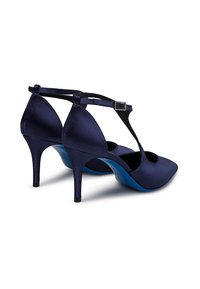 Scarpe con tacco alto in satin blu navy, con punta affusolata, cinturino alla caviglia e soletta blu. Presentano un design con ritagli sui lati.