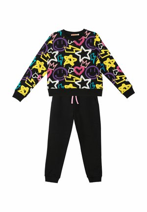 Sort træningsdragt med en farverig, legesyg sweatshirt dekoreret med smilende ansigtter, stjerner og lynmønstre. Sweatpantsene har snører.