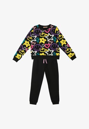 Zwarte trainingsoutfit met een kleurrijke, speelse sweatshirt versierd met glimlachende gezichten, sterren en bliksempatronen. De trainingbroek heeft een koord.