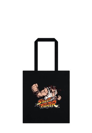 Czarna torba typu tote z muskularnym, animowanym wojownikiem w białym gi, rzucającym cios nad logo „Street Fighter” napisanym pogrubioną czcionką.