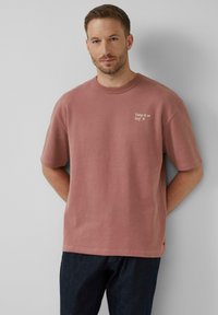 Übergroßes T-Shirt mit kurzen Ärmeln aus staubrosa Baumwolle und Rundhalsausschnitt, mit weißem Text "Take it or leaf it" auf der Brust.