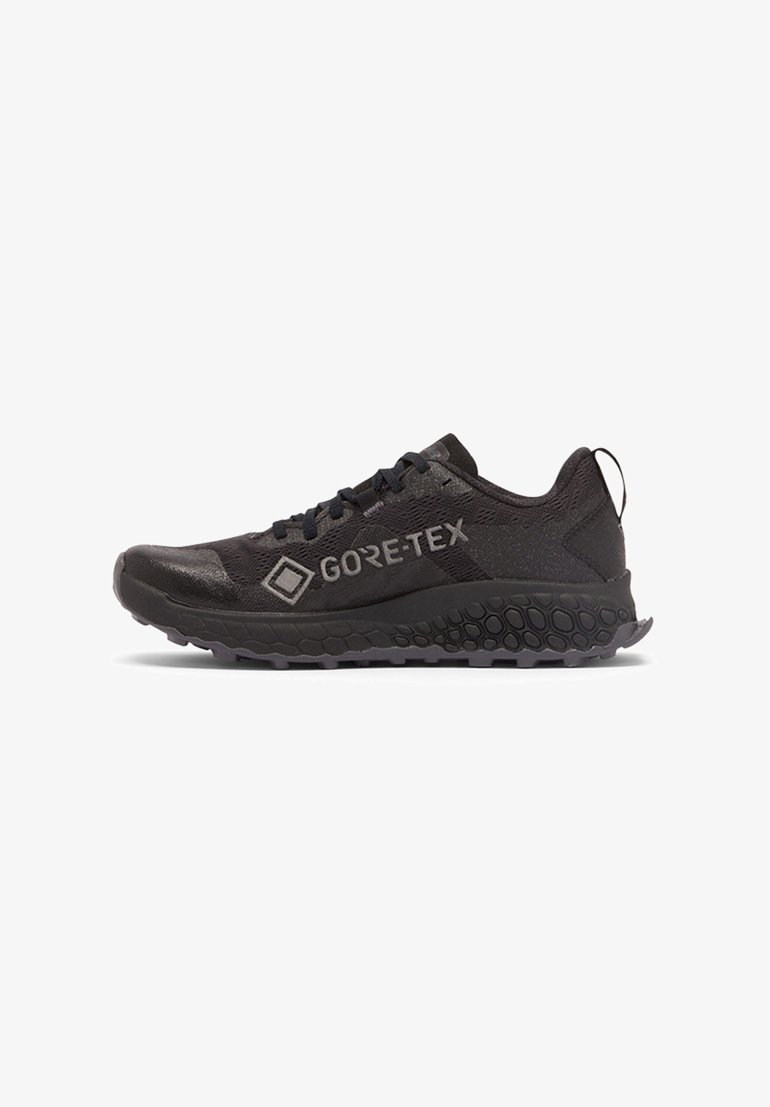 Black Gore-Tex running shoe with hexagonal-patterned sole and pull tab at heel, viewed from the outer side.