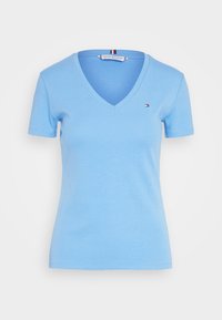 Světle modré bavlněné tričko s výstřihem do V, krátkými rukávy a malým kontrastním logem Tommy Hilfiger na levé hrudi.