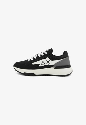 Sneakers neri con dettagli bianchi, dotati di una tomaia texturizzata, colletto imbottito e una spessa suola intermedia bianca. Il logo laterale è visibile.