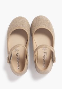 Scarpe Mary Jane in tessuto beige con punta arrotondata, tomaia testurizzata e una fascia con fibbia laterale per la regolazione. Fodera liscia e interno beige.