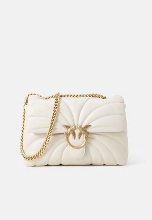 Krémová prešívaná kožená kabelka so zlatým reťazovým popruhom, ktorá má zaoblený zámok ozdobený detailmi vtáčikov a skladaný dizajn.