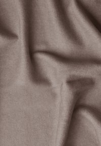 Tissu texturé et doux dans une couleur taupe atténuée, affichant des drapés et des plis naturels, avec une apparence veloutée et une surface lisse.