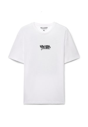 T-shirt bianca in cotone con maniche corte e scollo rotondo, con testo in stile graffiti nero sul davanti. Vestibilità rilassata, etichetta visibile all'interno.