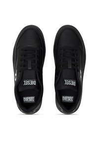 Baskets noires avec un dessus en cuir lisse, design perforé, lacets noirs et logo "DIESEL" blanc sur le côté. Semelle en caoutchouc plate.