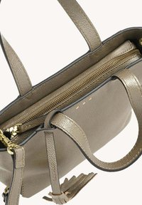Petit sac à main en cuir vert olive avec quincaillerie dorée, un compartiment zippé et deux poignées assorties. Fini texturé avec des accents minimales.