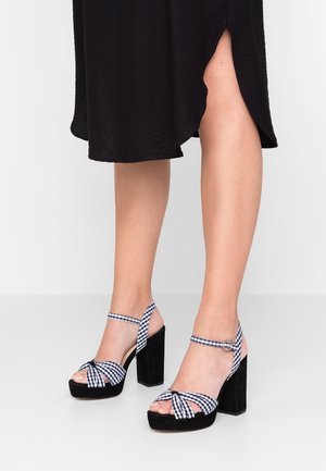 Sorte velour platåsandaler med detalje i ternet sløjfe; ankelrem med spænde. Kvadratisk hæl; åben tå, så fødderne kan ses.