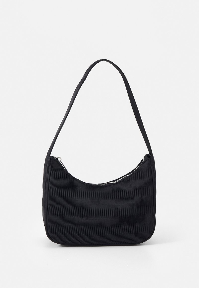 Sac d'épaule en tissu noir texturé avec une fermeture éclair incurvée sur le dessus et une bandoulière fine, présenté sur un fond uni.