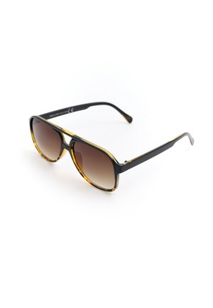 Czarne i lamparcie okulary przeciwsłoneczne typu aviator z brązowymi soczewkami gradientowymi na białym tle.