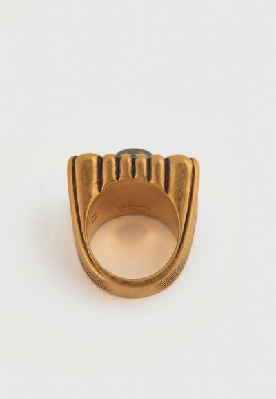 Δαχτυλίδι από μέταλλο με χρυσό τόνο, με ανάγλυφο πάνω μέρος και πράσινη πέτρα στο κέντρο, χαραγμένο εσωτερικά με "VERSACE Made in Italy".