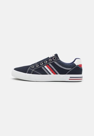 Baskets navy blue à enfiler avec semelle blanche, rayures rouges et blanches sur le côté et le talon, et œillets argentés sans lacets.