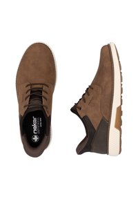 Chaussures en cuir marron avec une finition texturée, présentant un design à lacets, une semelle blanche et des accents contrastants en marron foncé sur le talon et les côtés.