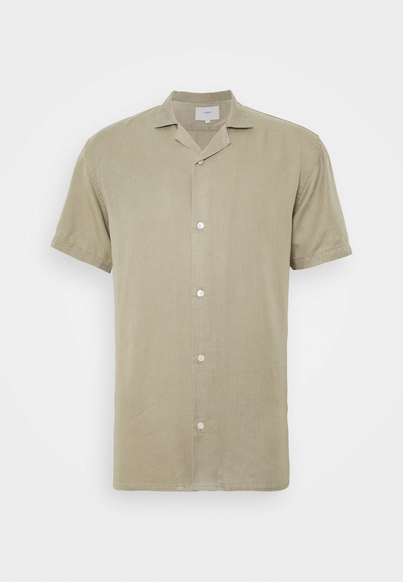 Chemise beige à manches courtes avec boutons et col camp, fabriquée en tissu léger, présentée sur un fond uni.