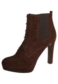 Botín de ante marrón con tacón alto, cierre de cordones en la parte frontal, paneles elásticos en los laterales y perforaciones decorativas a lo largo de las costuras.