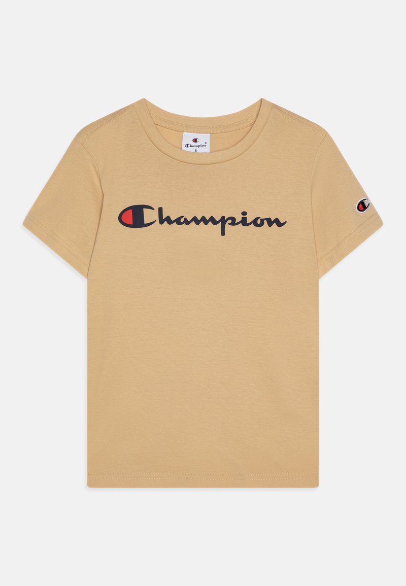 Beige t-skjorte med kort erme som har en svart "Champion"-logo over fronten og et lite logo-påklips på venstre erme. Glatt tekstur.