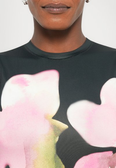 Top din țesătură neagră cu modele mari de flori roz, realizate în stil acuarelă; vedere detaliată a gâtului și umărului, având o textură netedă și un design ajustat.