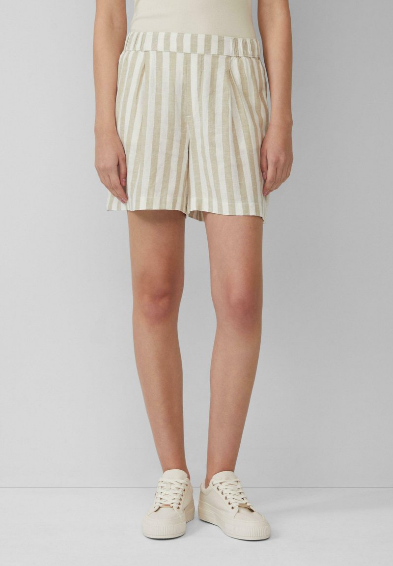 Leinenmischung Shorts mit vertikalen beige- und weißen Streifen, gefalteter Vorderseite, elastischem Bund, kombiniert mit cremefarbenen Sneakers.