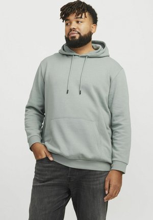 Lichtgroene hoodie van een katoenmix; heeft een voorzak, een capuchon met trekkoord en ribgebreide manchetten. Gepaard met donkere jeans.
