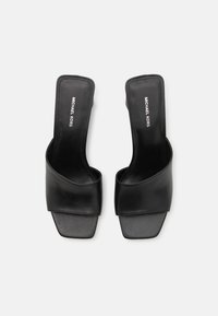 Sorte lædersandaler med bred forreste rem og firkantet tå. Udstyret med minimal branding på indersålen og glat tekstur.
