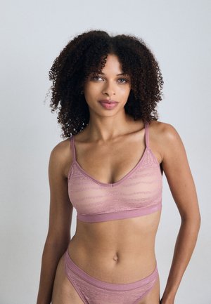 Lingerie-set i myk rosa med et gjennomsiktig, mønstrete design. Har justerbare stropper og en minimalistisk snitt. Glatt tekstur gjennom hele.